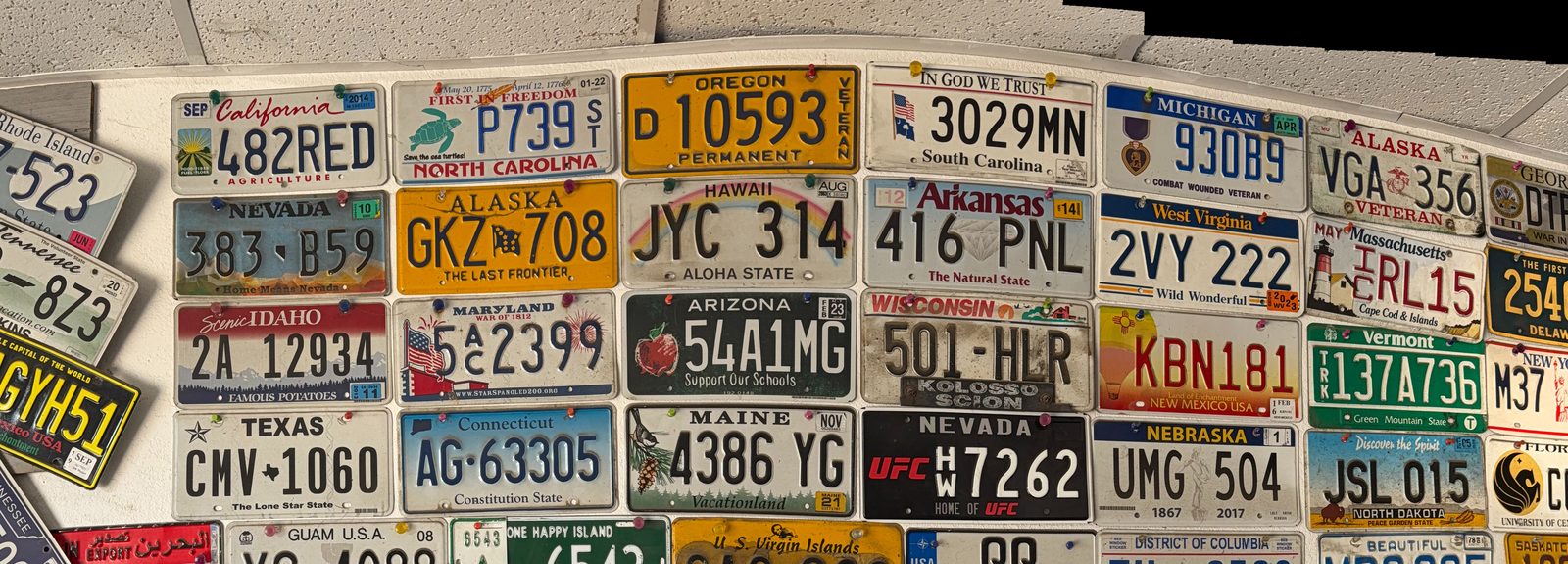 Wall of license plates from customers across the country at Valley Smog Test Only